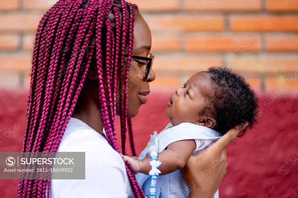 Young woman carrying baby boy