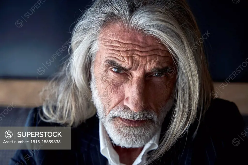 Serious male professional with gray hair at hotel