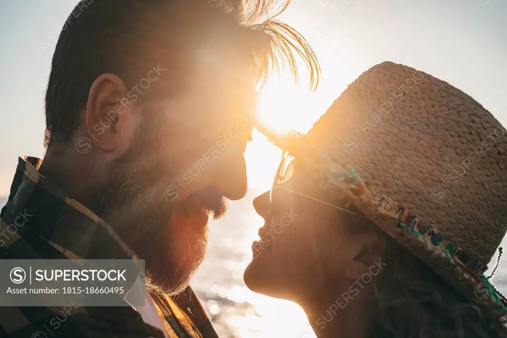 Bearded man romancing with girlfriend during sunset