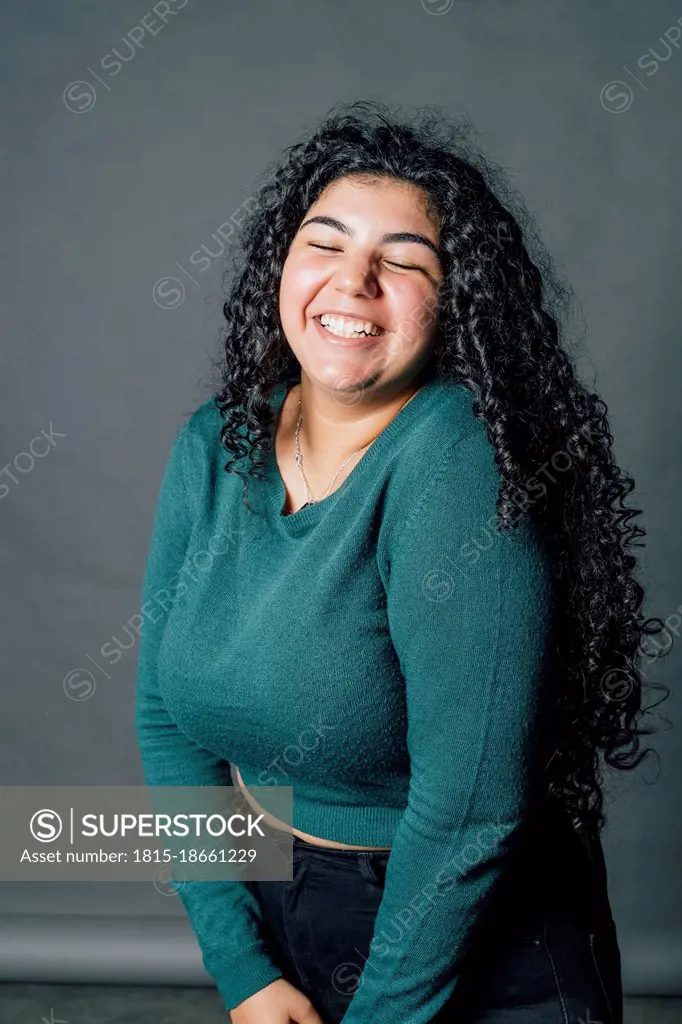 Happy young oversized woman laughing in studio