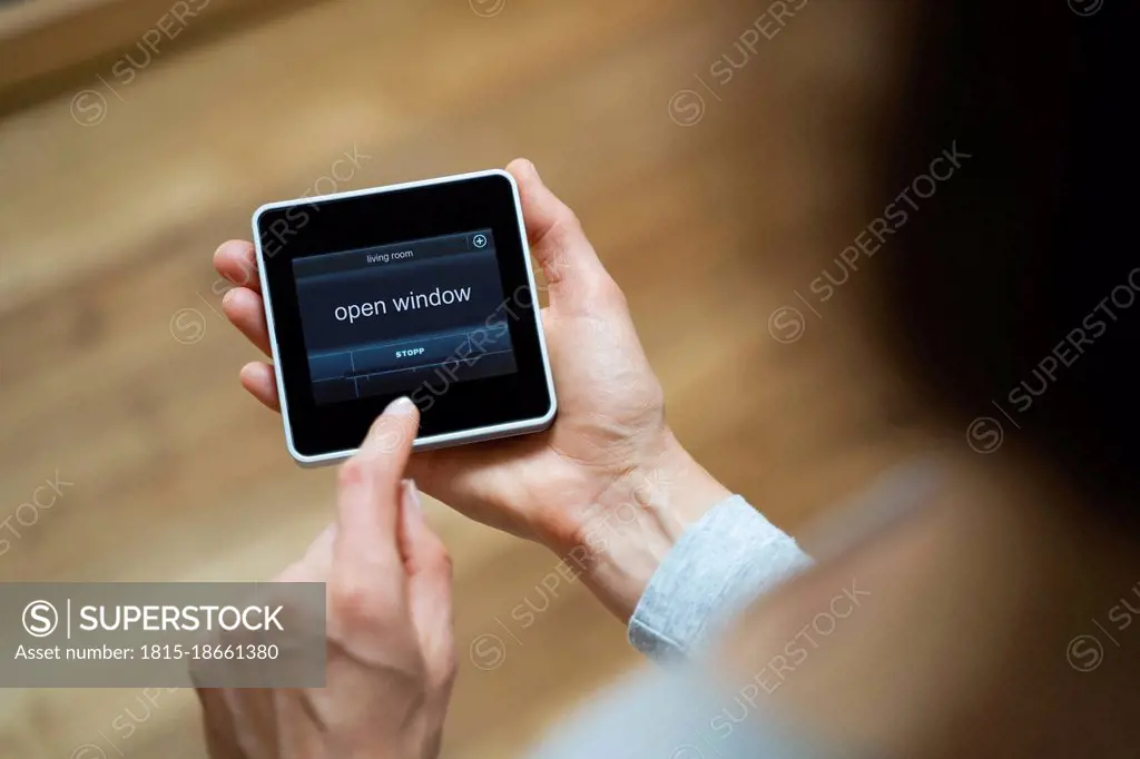 Mid adult woman operating smart home device