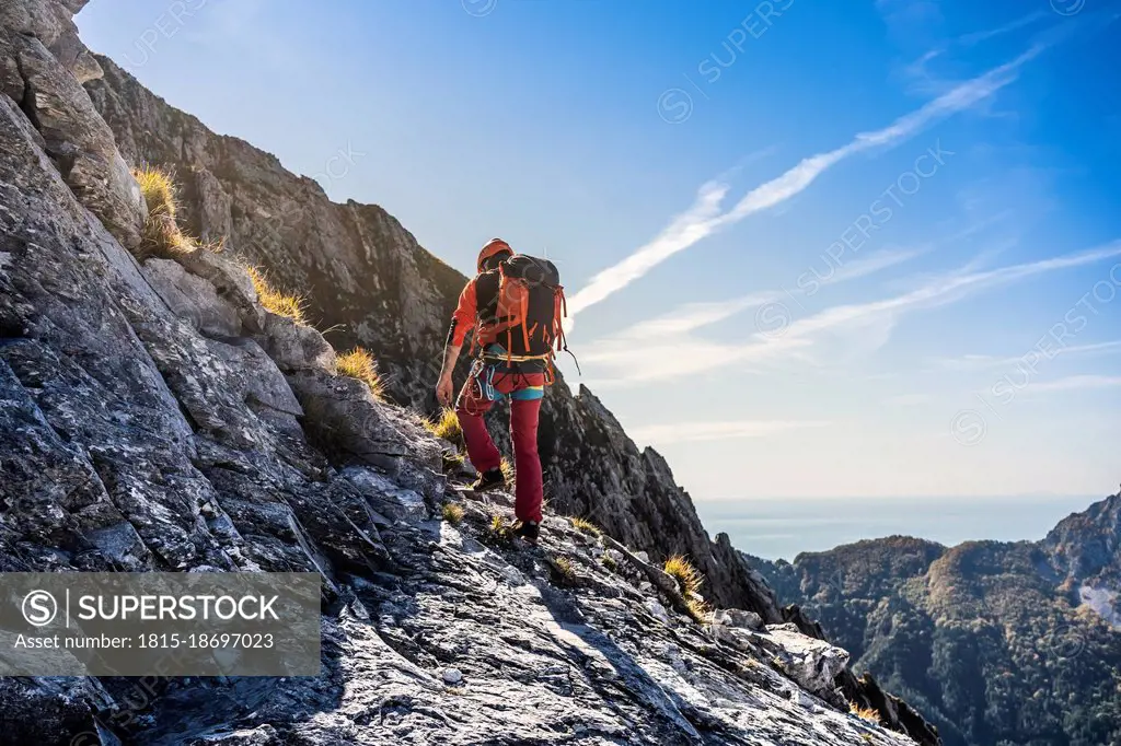 Male alpinist hiking on adventurous mountain trail