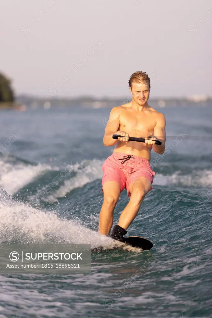 Young man waterskiing in lake