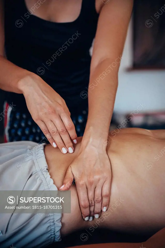 Massage therapist massaging man at spa