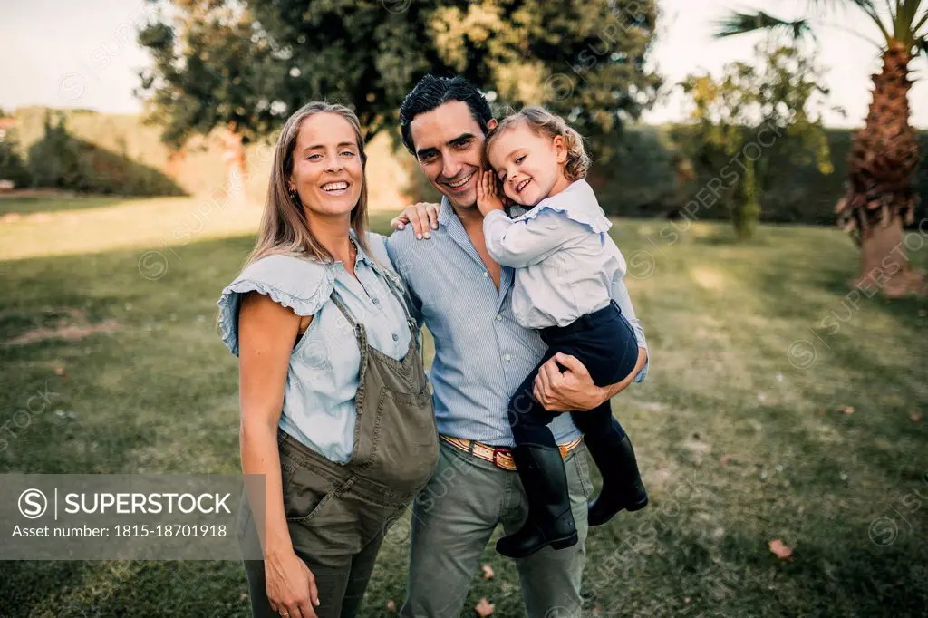 Smiling parents with daughter at ranch