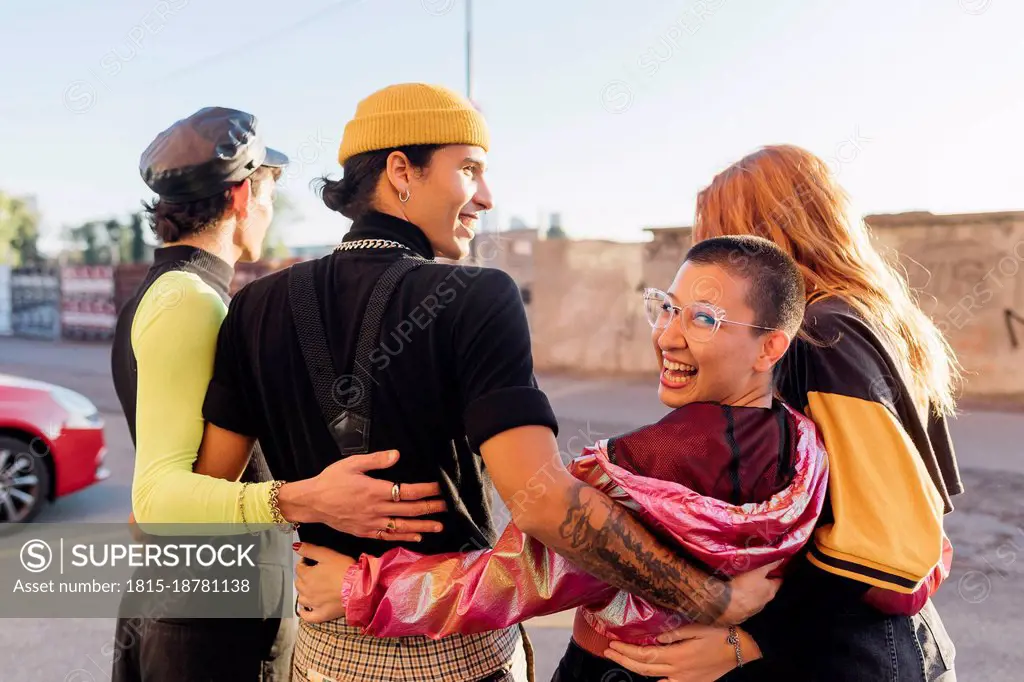 Happy woman with arm around friends on road