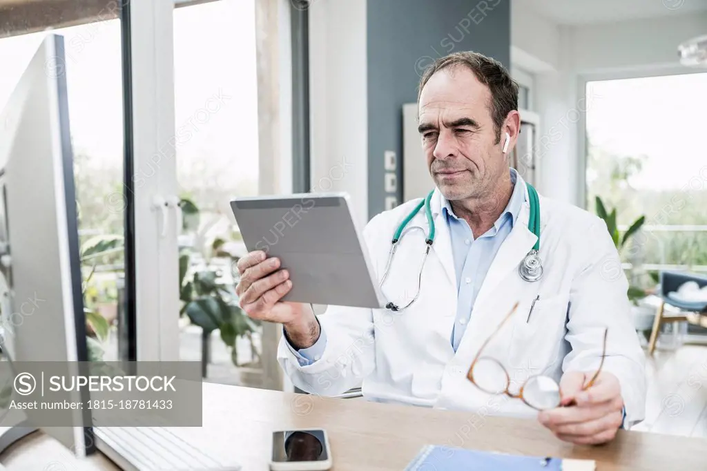 Doctor staring at digital tablet in medical clinic