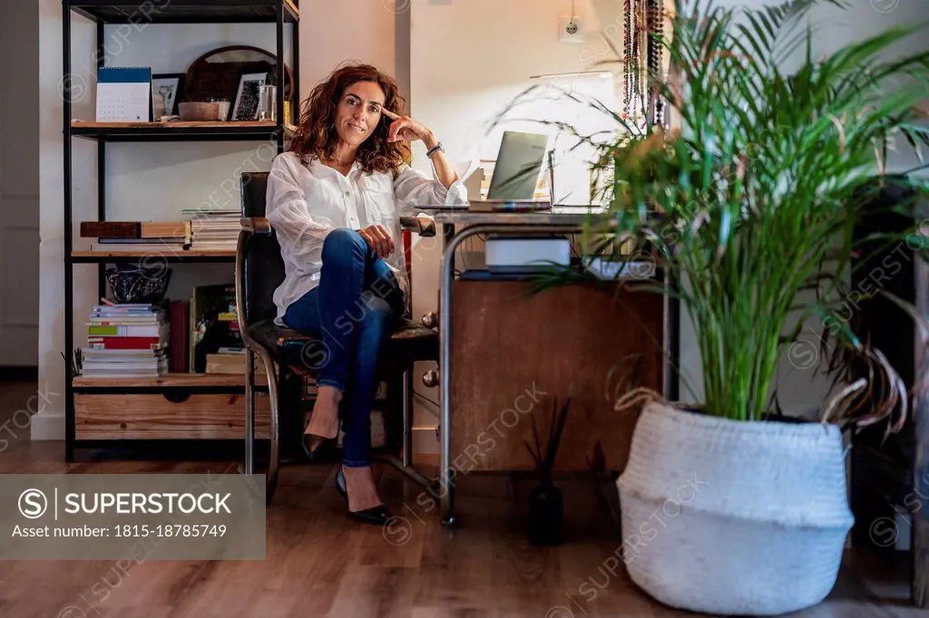 Woman with laptop sitting at home office