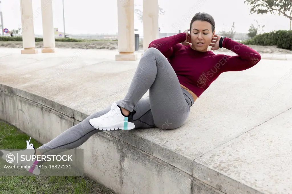 Woman doing exercising on concrete at park