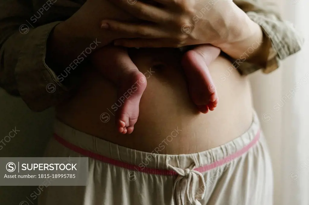 Woman carrying baby son at home