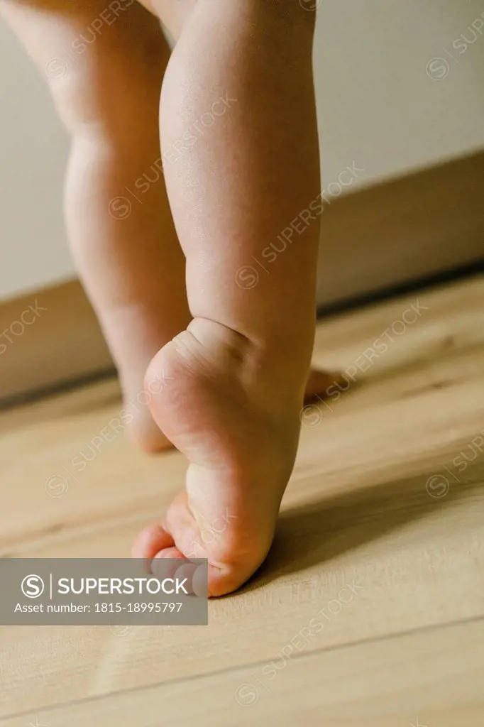 Cute boy with barefeet on floor at home