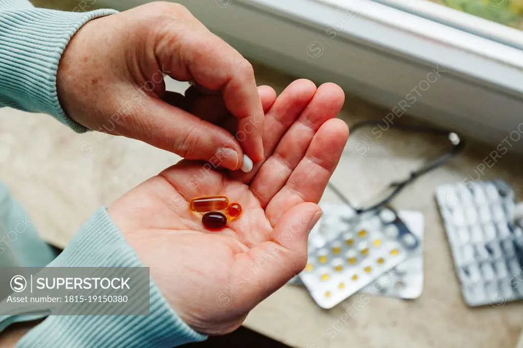 Senior woman with medicine pills in hand