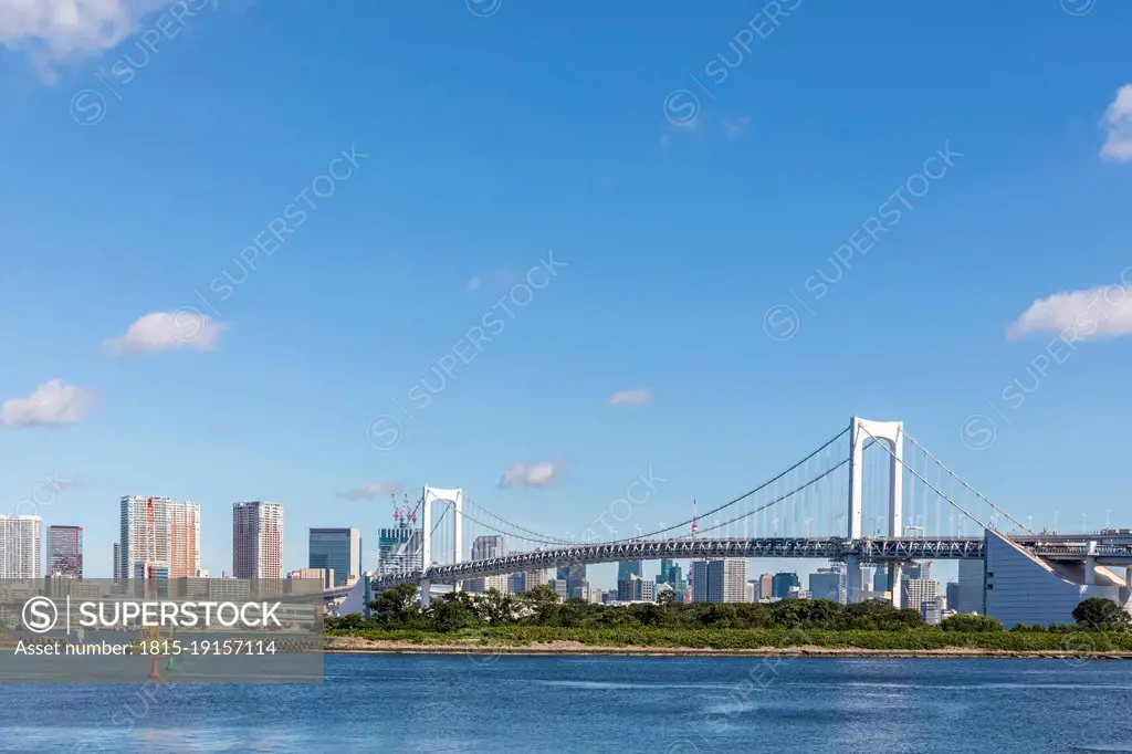 Japan, Kanto Region, Tokyo, View of Odaiba island with Rainbow bridge in background