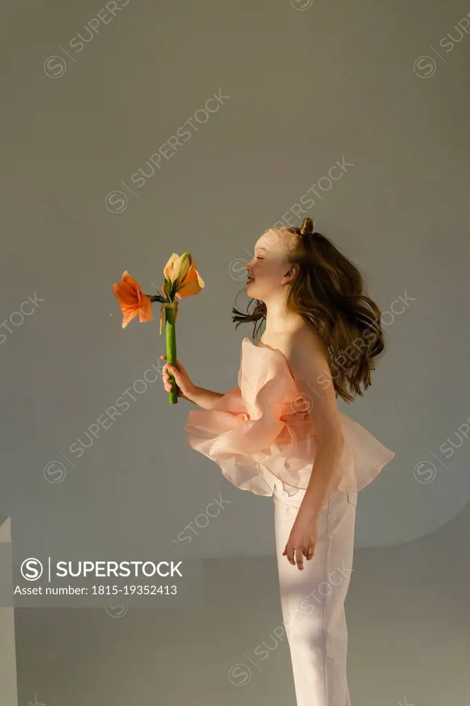 Cute girl jumping with flowers in hand