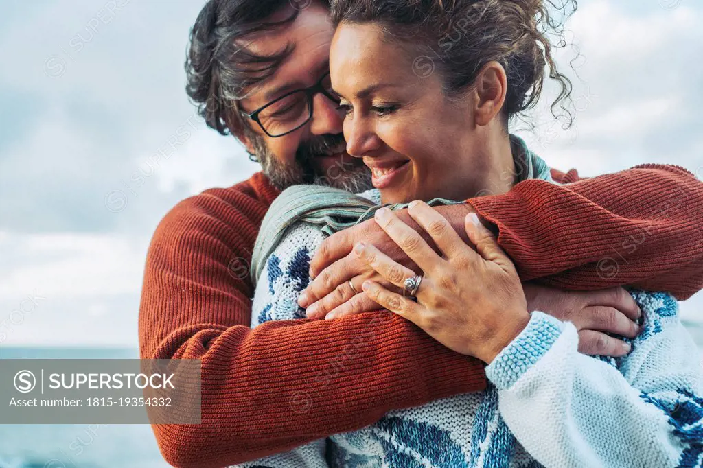 Happy man embracing woman from behind