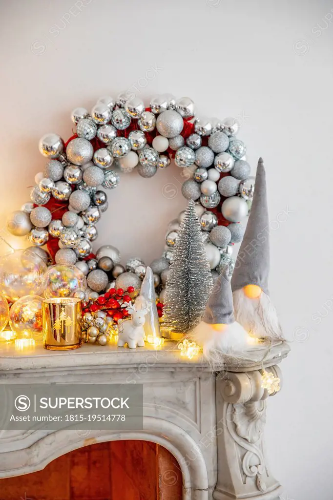 Christmas decoration with illuminated lights on marble fireplace