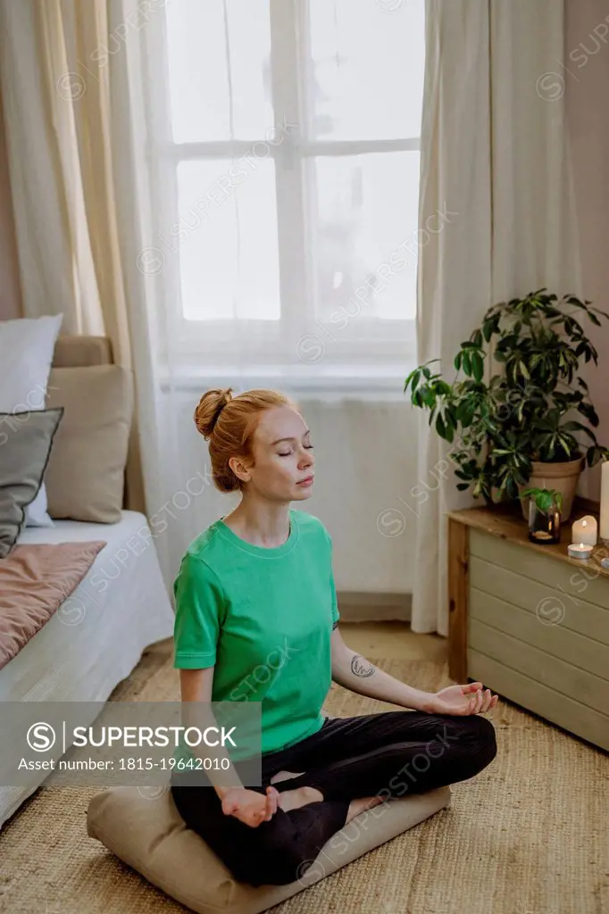 Woman with eyes closed meditating at home