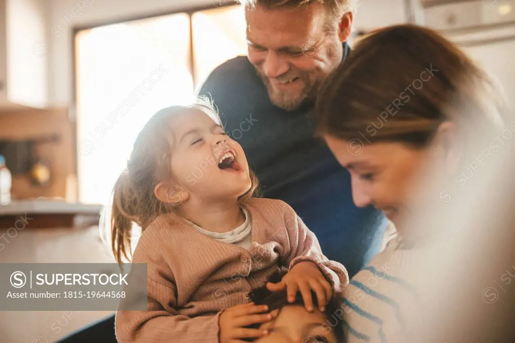 Playful parents with son and daughter at home