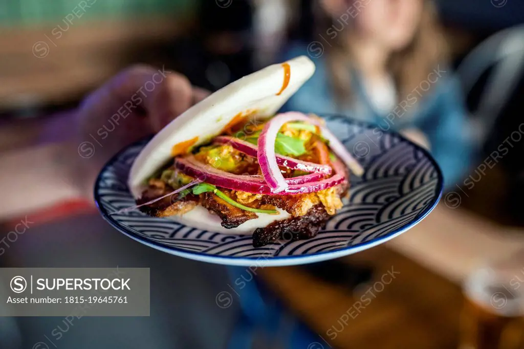 Waitress holding plate with food at restaurant