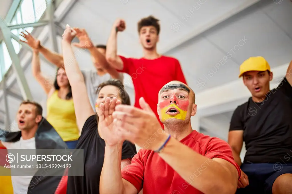 Young fans cheering at sports event in stadium