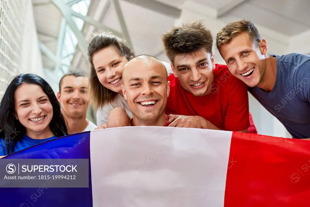 Happy sports fans with French Flag in stadium