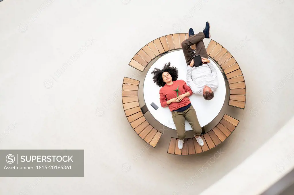 Business colleagues resting on table in office lobby