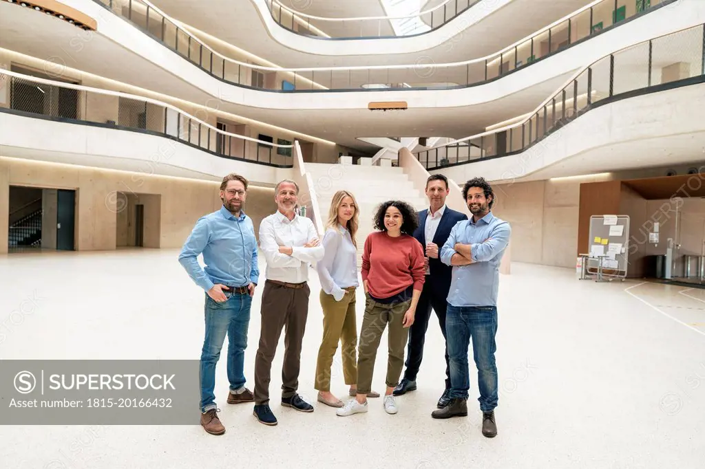 Smiling multiracial business colleagues standing in lobby