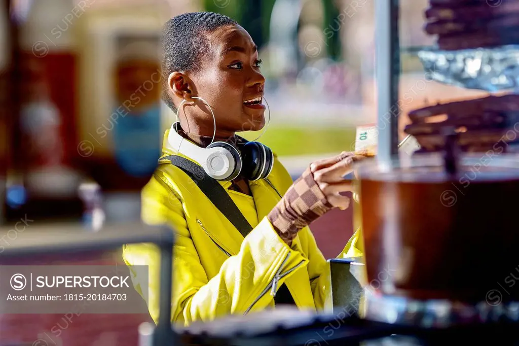 Woman with headphones buying food at concession stand