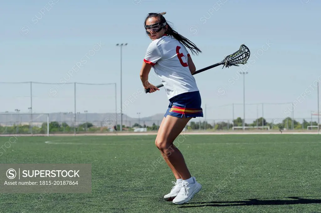 Player with lacrosse stick playing on sports field