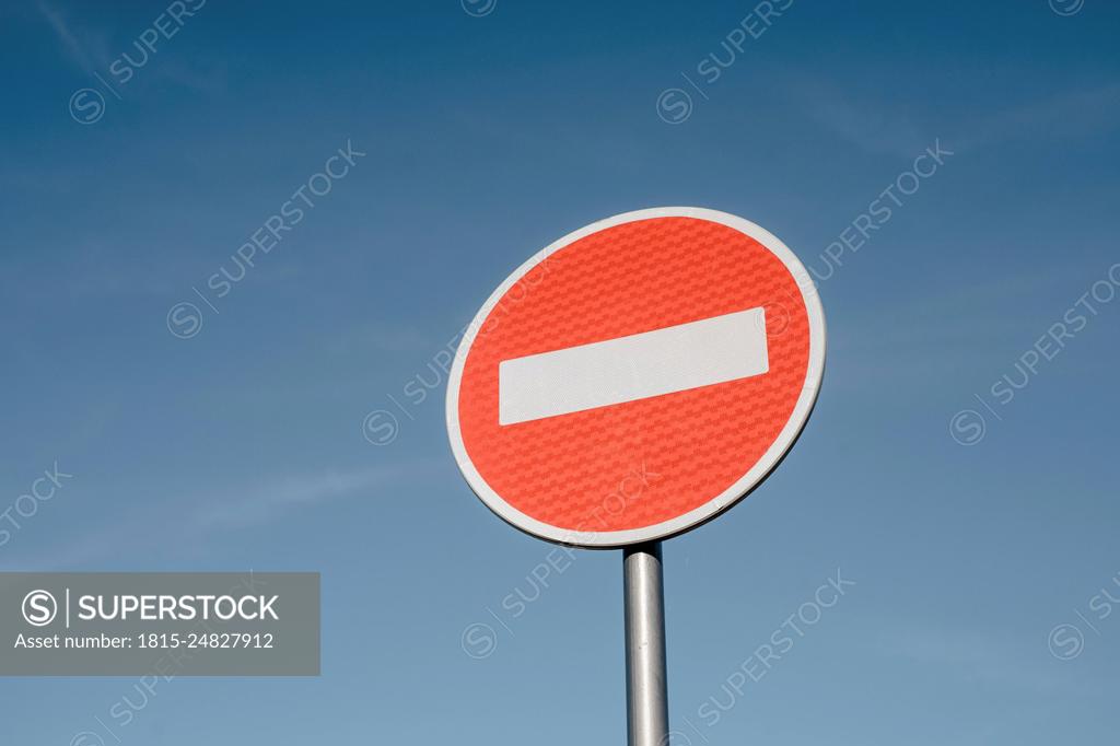 Passage forbidden with round traffic sign in front of blue sky in