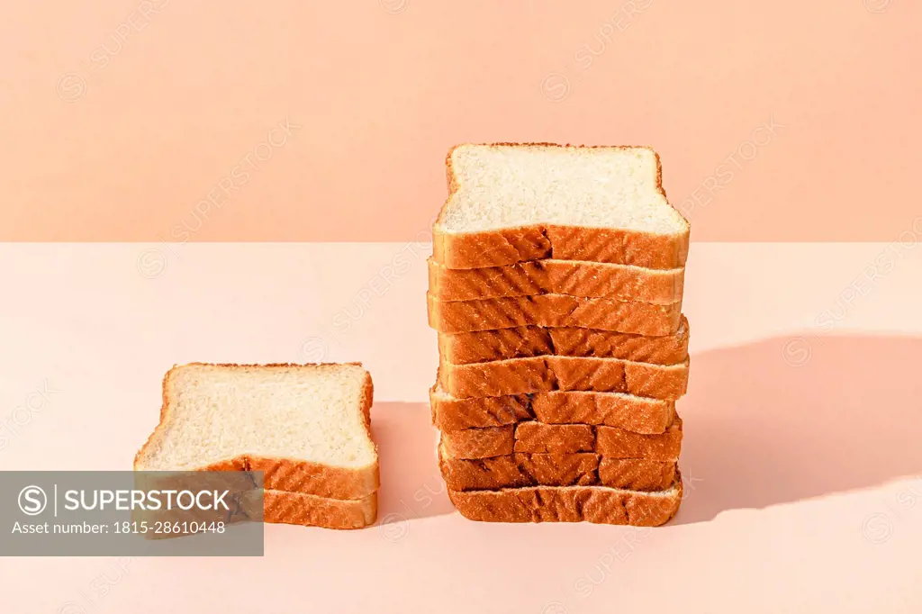 Stack of bread slices against peach background