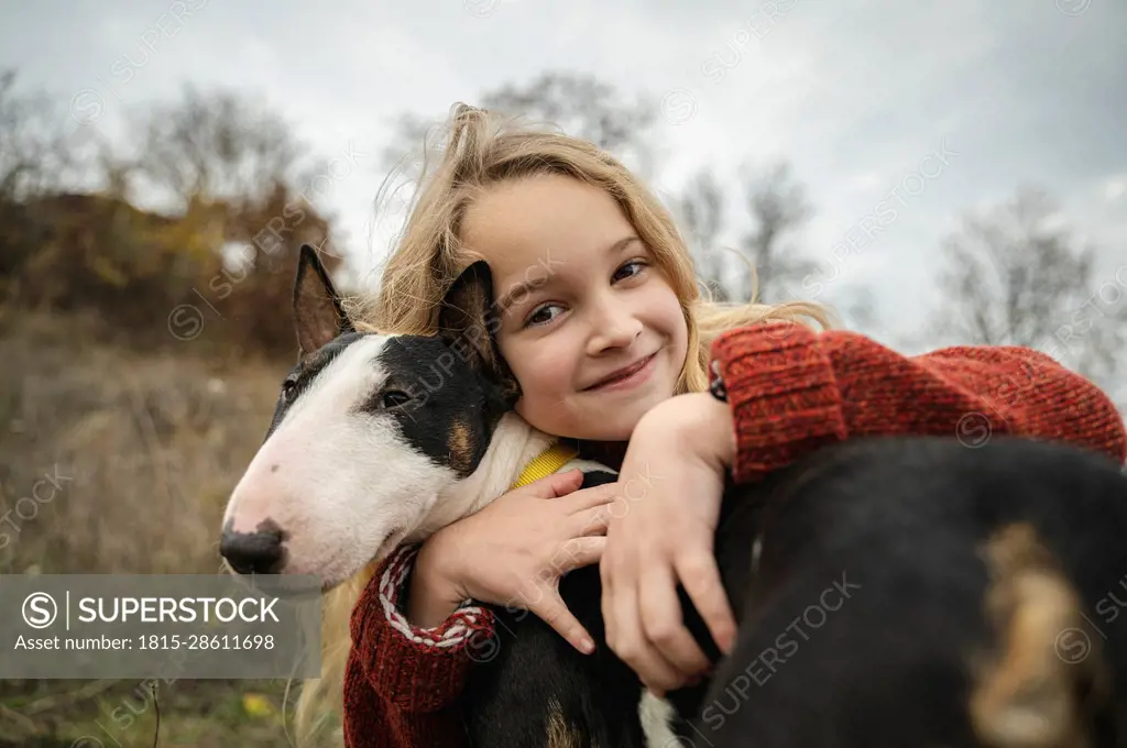 Smiling cute girl embracing dog