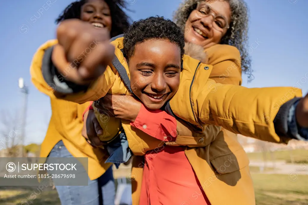 Happy multi-generation family having fun in park on sunny day