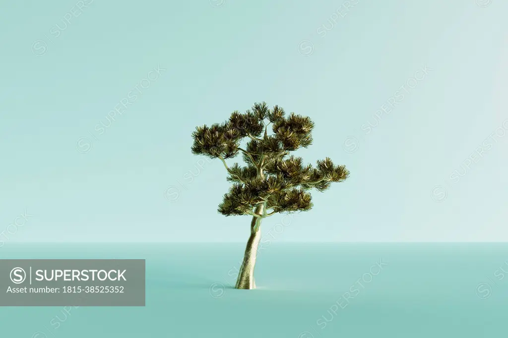 Three dimensional render of lone gold colored tree standing against blue background