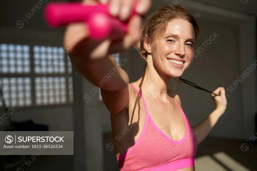 Smiling woman holding skipping rope