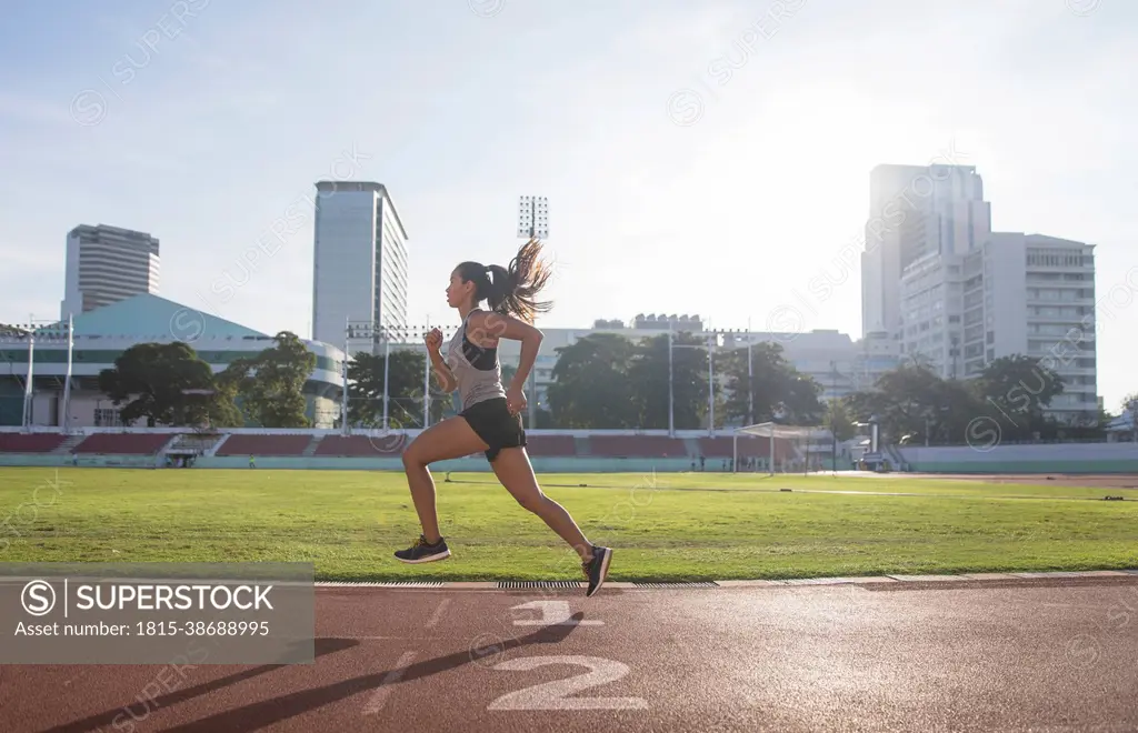 Young woman running in sports field