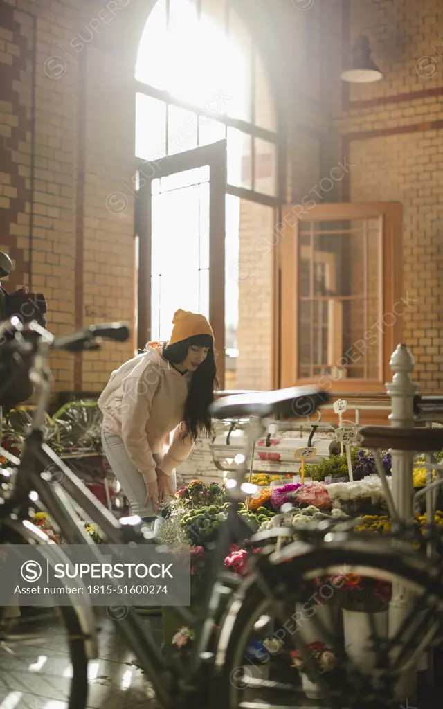 Woman choosing flowers to buy at shop