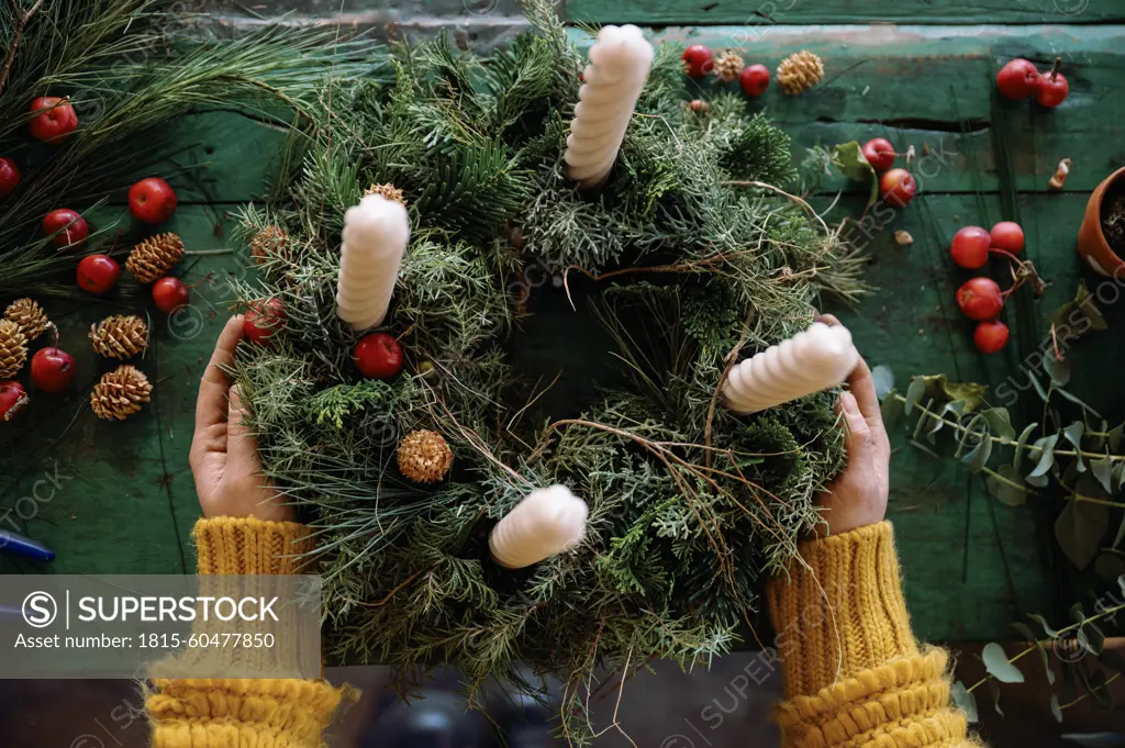 Florist making wreath on table in store