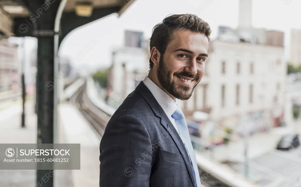 Smiling young businessman waiting at subway station