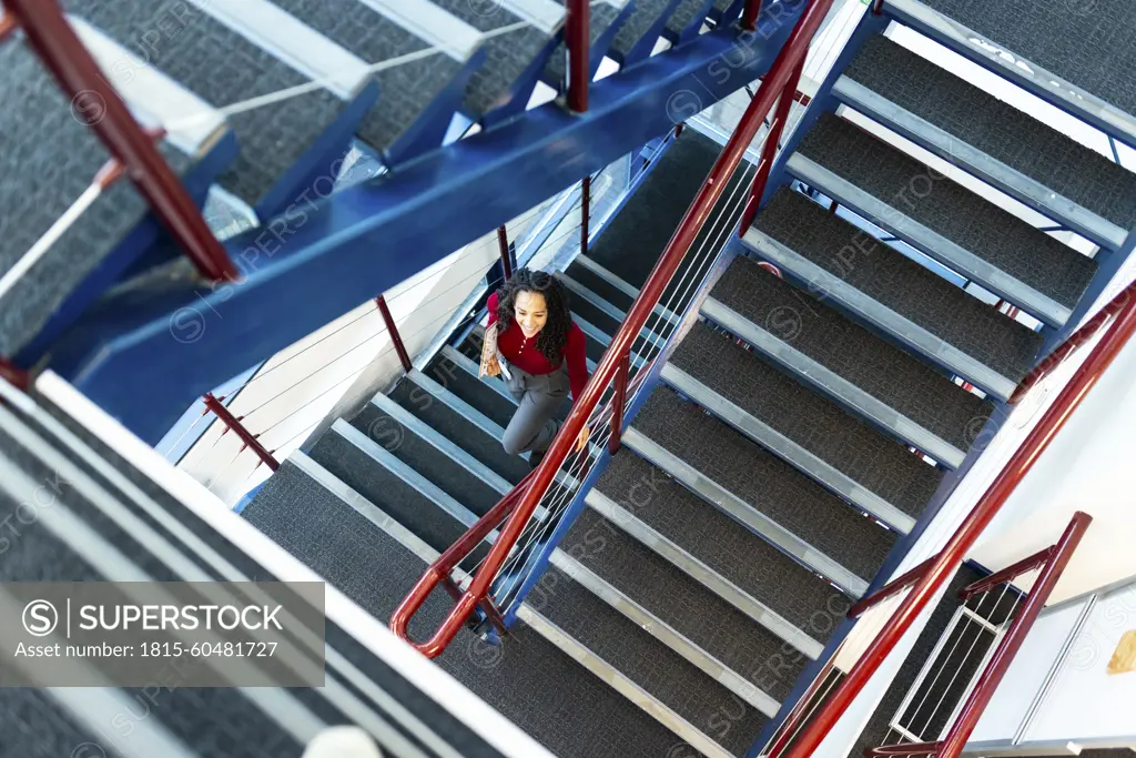 Businesswoman moving down from stairs at office