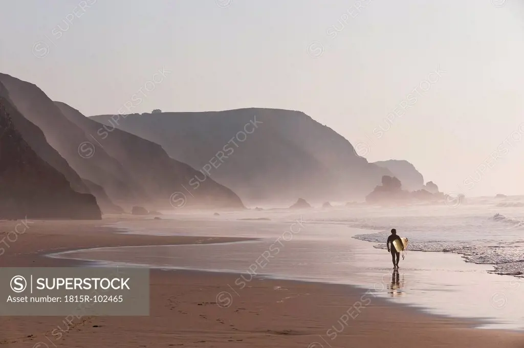 Portugal, Surfer walking on beach