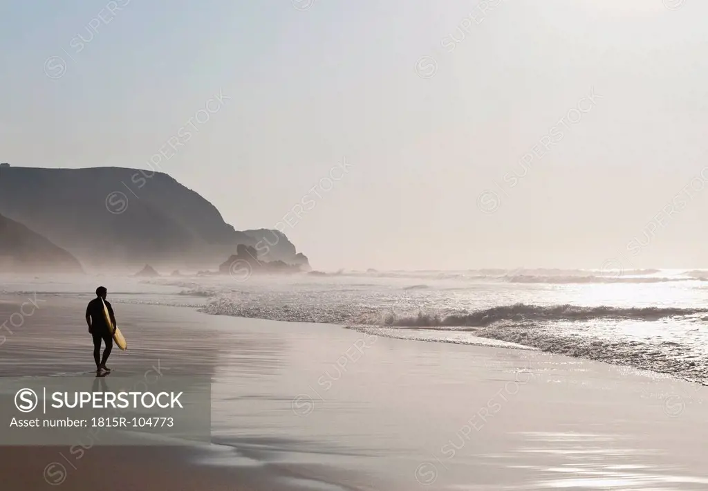 Portugal, Surfer walking on beach