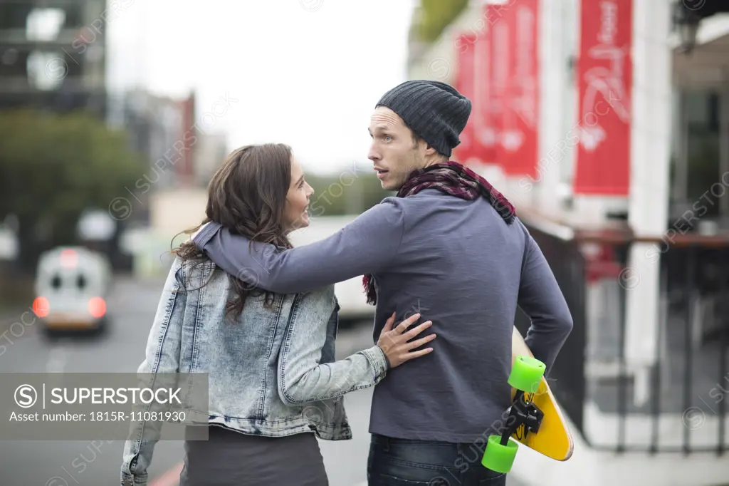 Young couple walking arm in arm on the street