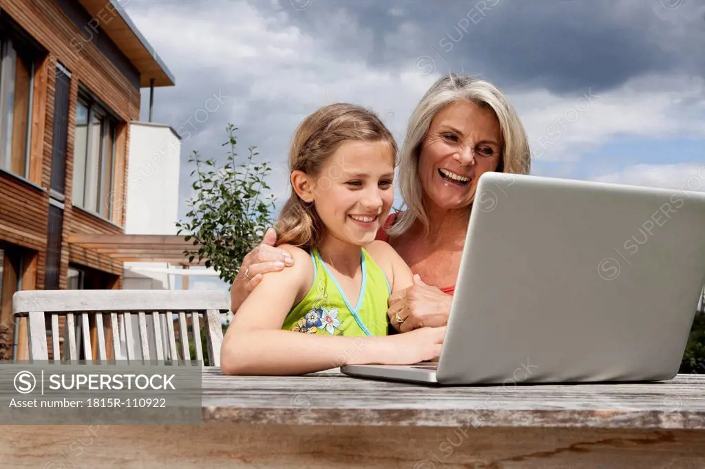 Germany, Bavaria, Nuremberg, Grandmother and granddaughter using laptop