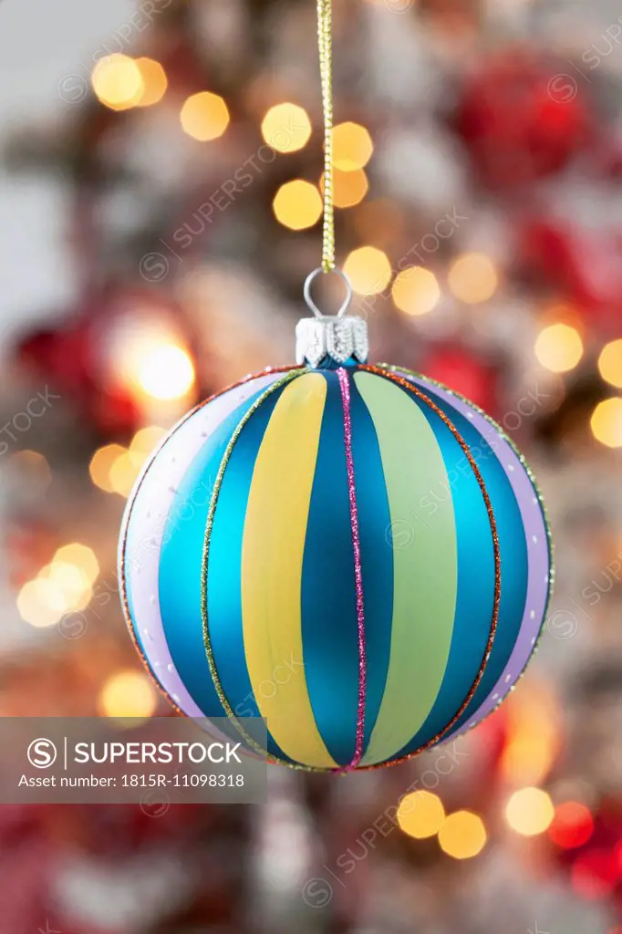 Christmas bauble hanging in front of blurred flares