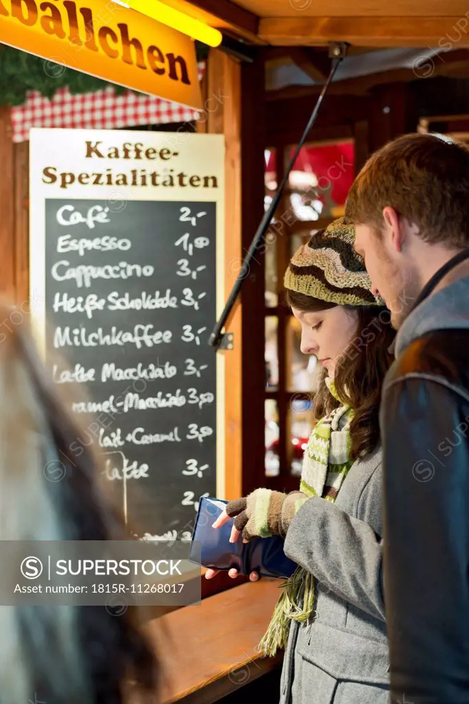 Germany, Berlin, young couple at Christmas market