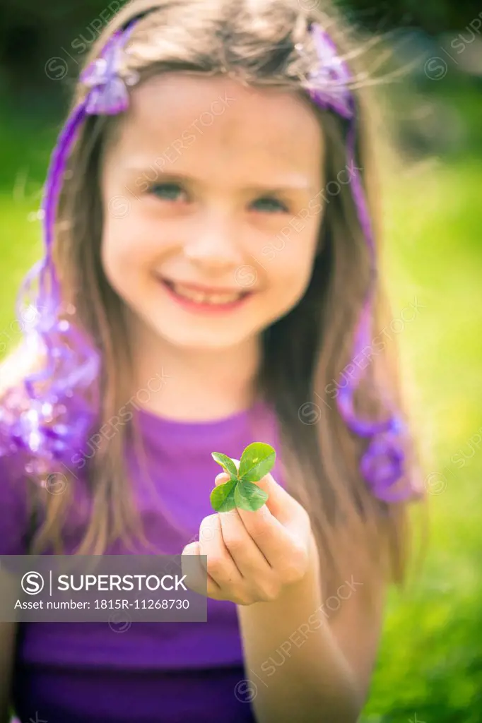 Little girl showing four leaved clover