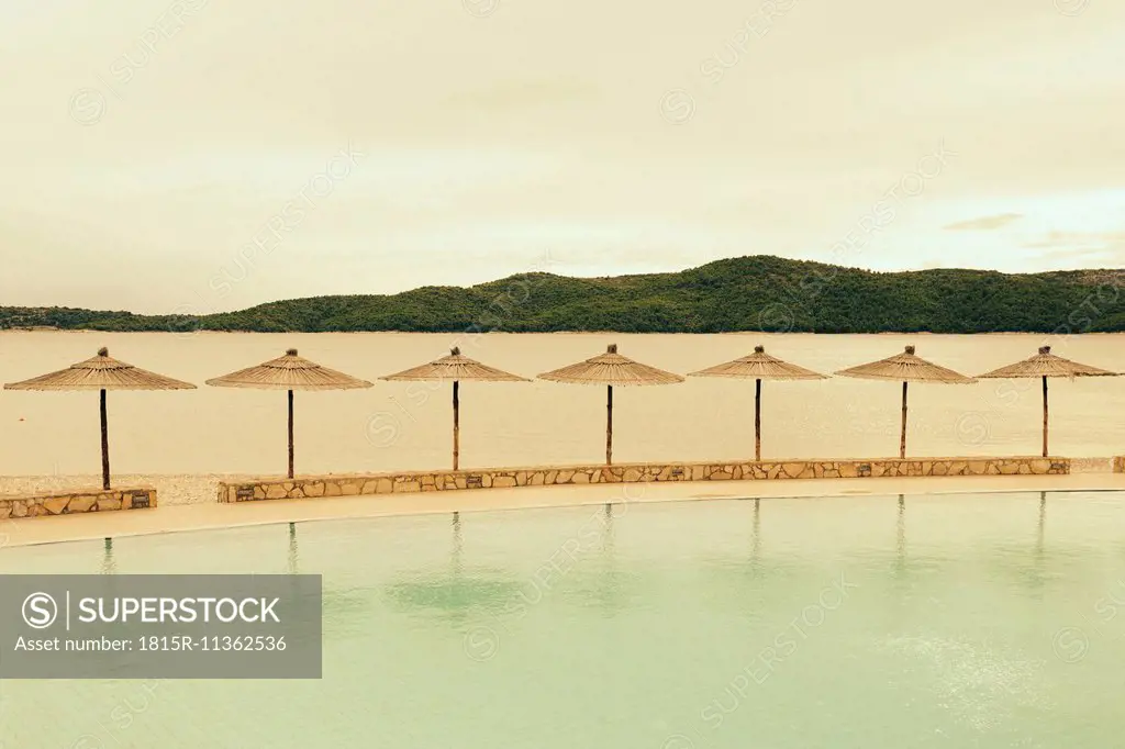 Croatia, Sibenik, Sunshades, Swimming pool of a hotel facility, Evening mood