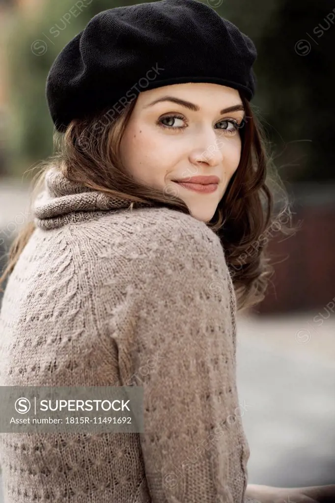 Portrait of smiling young woman wearing beret and knitted dress