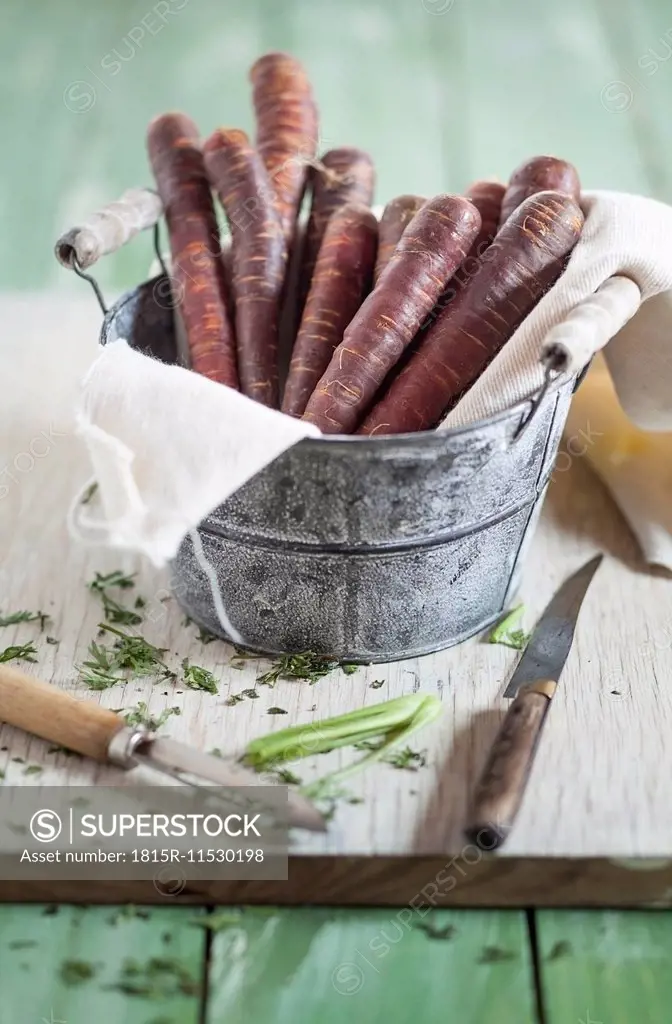 Pail of prepared Purple Haze, knife and peeler on wooden board